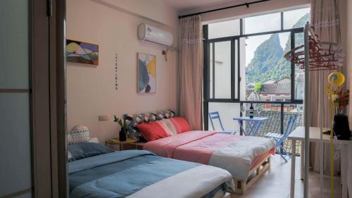 a bedroom with two beds and a balcony at Showbiz Hostel in Yangshuo