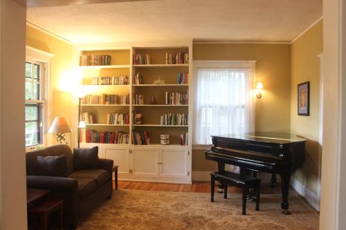 a living room with a piano and a book shelf at Brown Street Inn Bed and Breakfast in Iowa City
