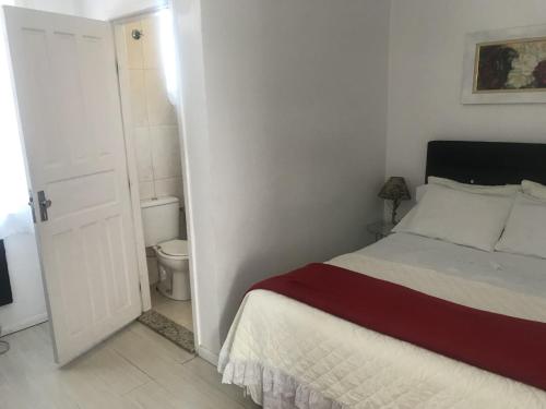 a white bedroom with a bed and a toilet at Hotel pousada porto real in Morretes