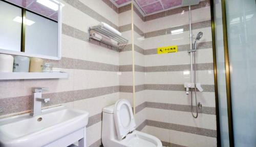 a bathroom with a shower and a toilet and a sink at Showbiz Hostel in Yangshuo