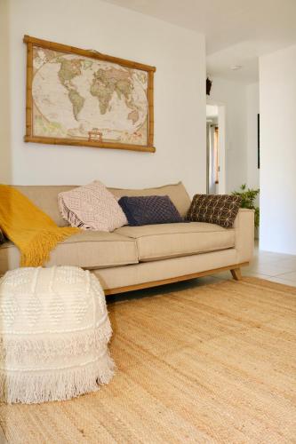 a couch in a living room with a map on the wall at Surf Shack in Iconic Rainbow Bay - Coolangatta QLD (pet friendly) in Gold Coast