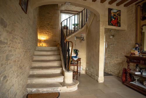 a stone hallway with stairs in a house at Le Clos des Courtines - Les 4 Vents in Meuvaines