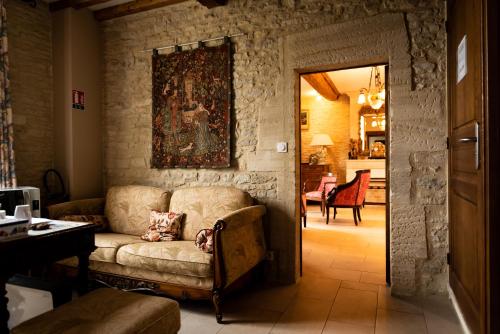 a living room with a couch and a painting on the wall at Le Clos des Courtines - Les 4 Vents in Meuvaines