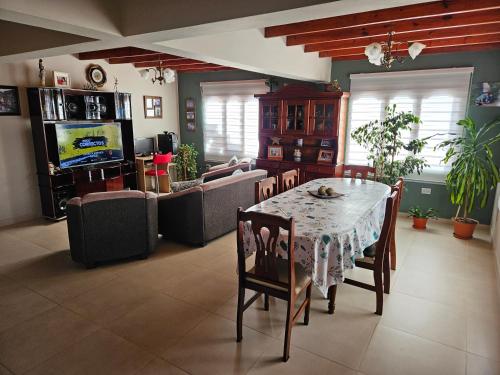 a living room with a table and chairs and a television at Casa de familia in Ushuaia