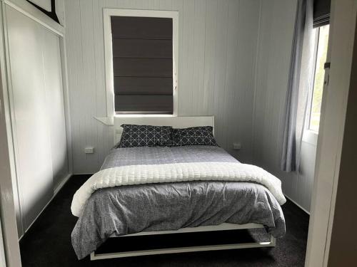 1 dormitorio con 1 cama grande y ventana en Country charm on acreage, en Kingaroy