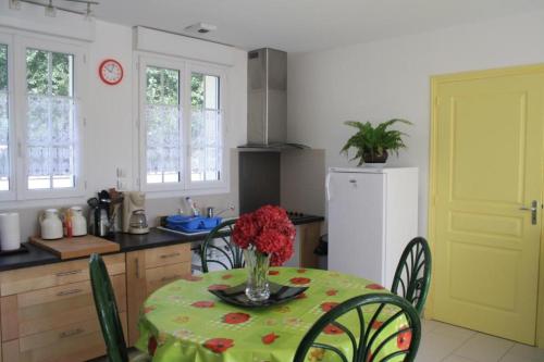 a kitchen with a table with a vase of flowers on it at Maison la Belle Plage in Asnelles