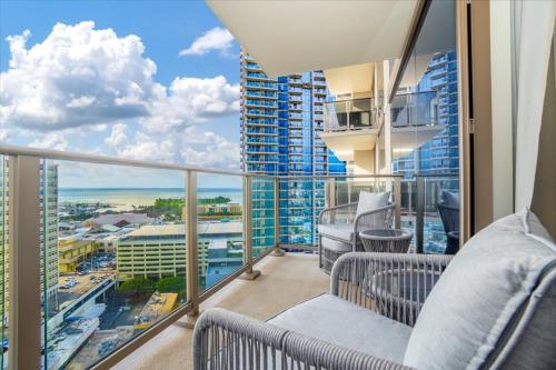 a balcony with chairs and a view of a city at Sky Ala Moana 2307 condo in Honolulu