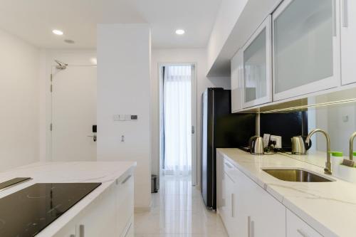 a white kitchen with a sink and a refrigerator at The RIYAZ Lavanya in Pantai Cenang
