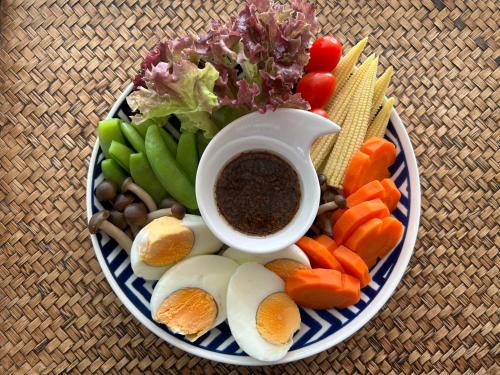 a plate of vegetables and a cup of coffee at BC Summer Beach in Pran Buri