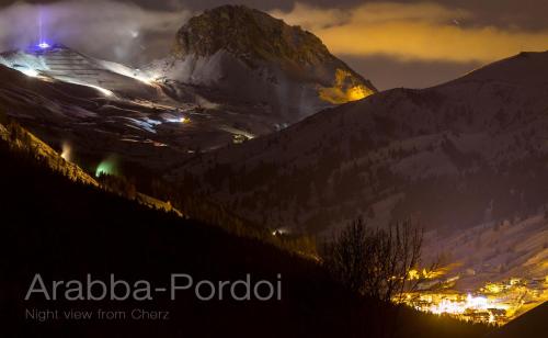 a view of a snowy mountain at night at Cèsa Raggio di Sole in Arabba