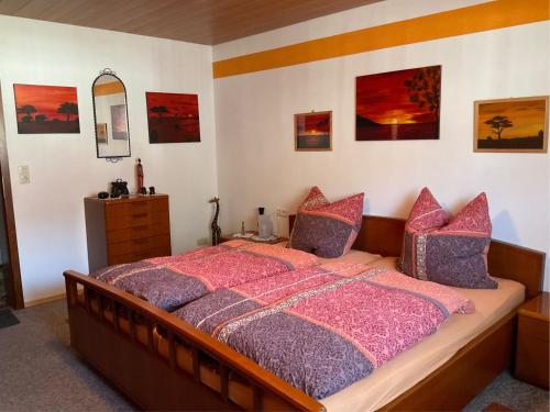 a bedroom with a bed with pink comforter and a mirror at Ferienwohnung Schwarzwälder in Hornberg