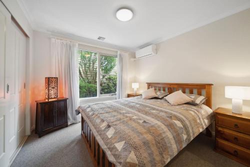 a bedroom with a large bed and a window at Holley House in Leura