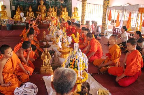 a group of men in orange robes sitting in a temple at DaViKa Hotel in Vientiane