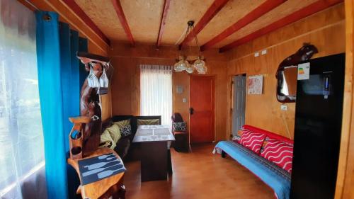 a living room with a couch and a table at Cabañas y Hospedaje Parque los Volcanes in Llanquihue