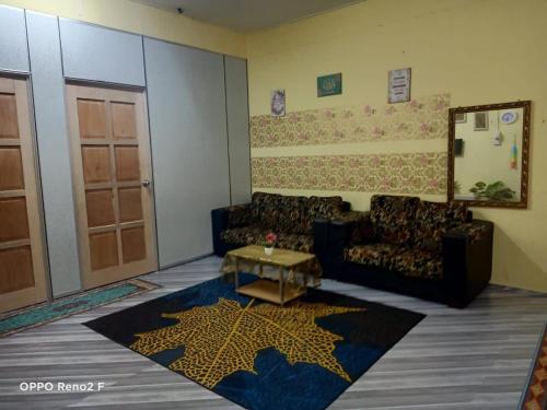 a living room with a couch and a star rug at D&I Homestay in Tumpat