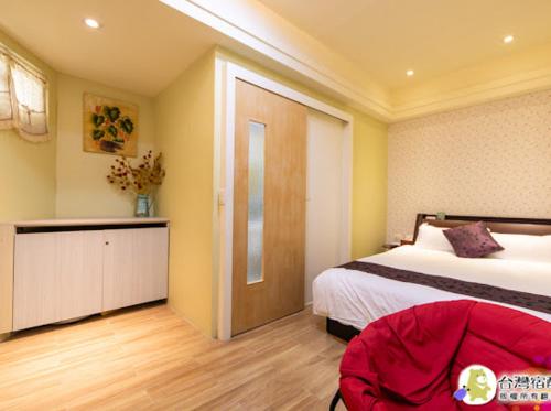 a bedroom with a bed and a room with a door at 花蓮幸福約定民宿4-12人包層,一天招待一組朋友,近花蓮市區中心,花蓮遠東百貨,花蓮文創,東大門夜市 in Hualien City