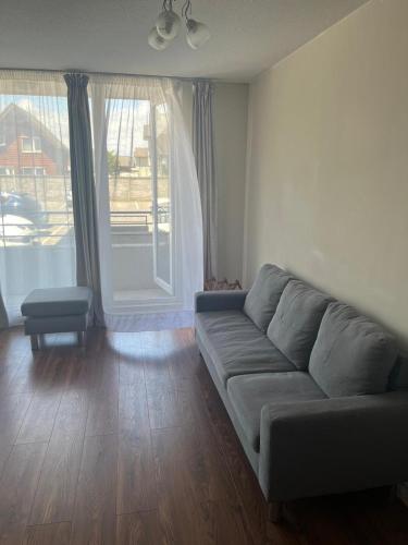 a living room with a couch and a large window at Cifmell Marina del Sol II in Talcahuano