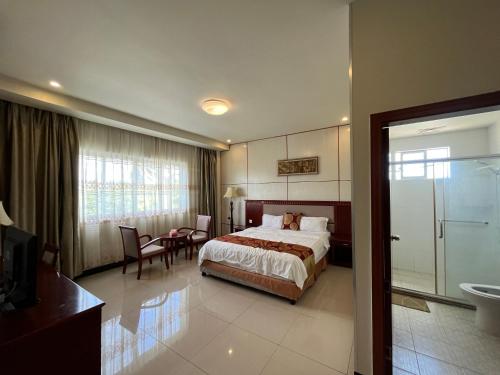 een hotelkamer met een bed en een tafel en stoelen bij Meida Hotel in Nuku‘alofa