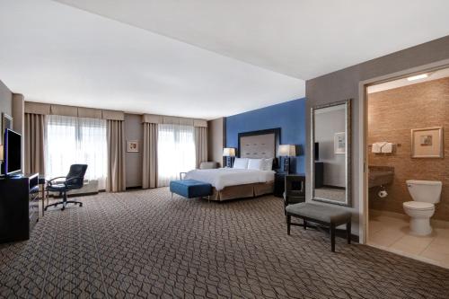 ロムルスにあるHoliday Inn Detroit Metro Airport, an IHG Hotelのベッドとバスルームが備わる広いホテルルームです。