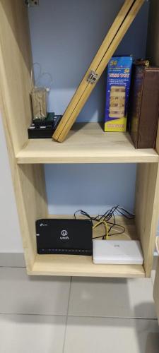 a shelf with a laptop and books on it at Hygge Living Kampar II (Near UTAR) in Kampar