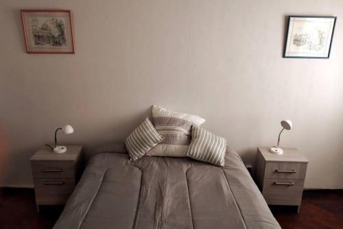 a bedroom with a bed with two night stands and two lamps at Roxi Aristides in Mendoza