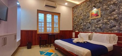 1 dormitorio con cama y pared de piedra en Empire Pool Villa, en Meenangadi