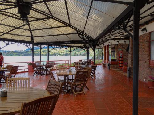 een restaurant met tafels en stoelen en uitzicht op het water bij Hotel Refugio Santa Ines in Aquitania