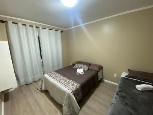 Un dormitorio con una cama con un gato. en Apartamento na rua coberta Gramado, en Gramado