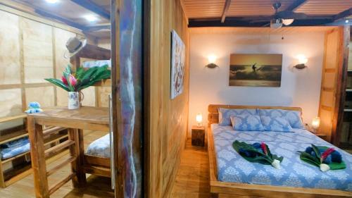 a bedroom with a bed and a table and a desk at Jungle Bluff Beach Paradise - Jungle House in Paunch