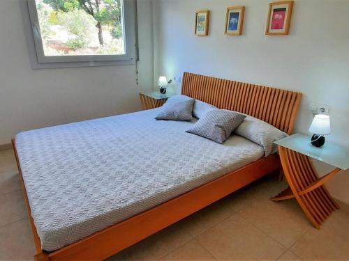 uma cama com duas almofadas num quarto em Apartamento Llançà, 3 dormitorios, 6 personas - ES-170-47 em Llançà