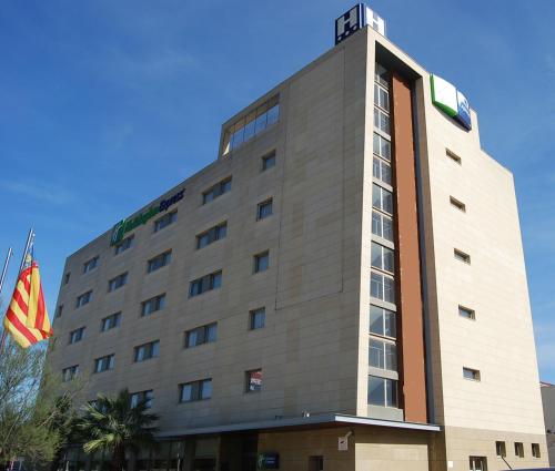 a building with a flag in front of it at Holiday Inn Express Valencia Bonaire by IHG in Aldaya