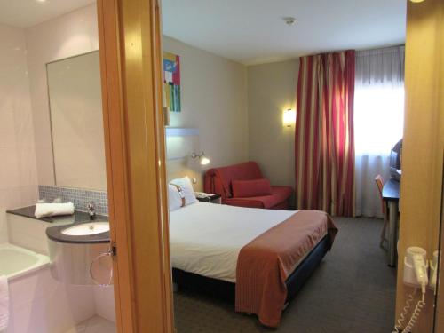 a hotel room with a bed and a bathroom at Holiday Inn Express Valencia Bonaire by IHG in Aldaya