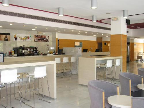 a restaurant with white chairs and a counter with a bar at Holiday Inn Express Valencia Bonaire by IHG in Aldaya