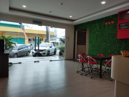 a room with a green wall with a table and chairs at Mass Hotel in Kampong Kerayong