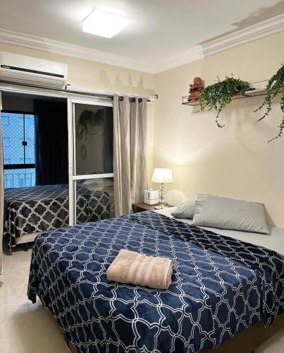 a bedroom with a bed with a blue comforter at Comfortable & Economic Acqua Village in Brasilia
