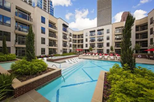 um complexo de apartamentos com uma grande piscina com cadeiras em Stylish Downtown Retreat em Houston