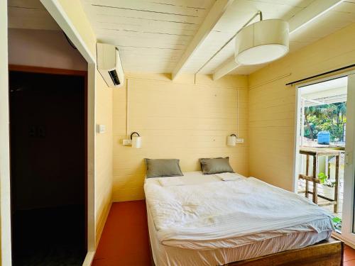 a small bed in a room with a window at Coco Hostel Goa in Palolem