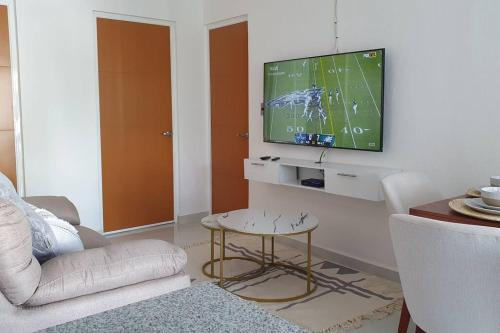 een woonkamer met een tv en een voetbalspel op het scherm bij Manzanillo Depto. ¡buena vibra! in Manzanillo