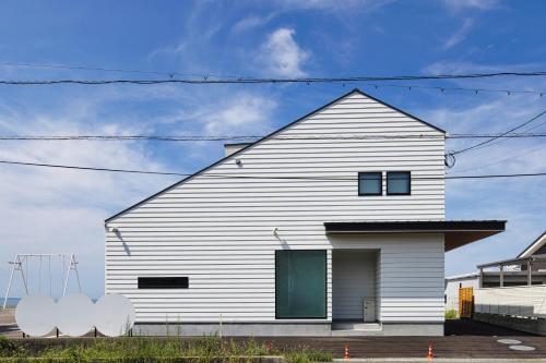 a white house with a green door at BHOLIC（ビーホリック） in Shimonoseki