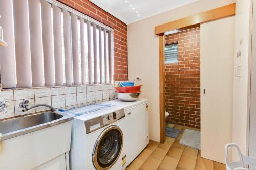 una cocina con lavadora y fregadero en Harmony, en Lakes Entrance