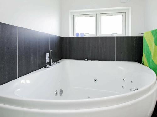 8 person holiday home in Haderslev في Årøsund: حوض أبيض كبير في الحمام مع نافذة