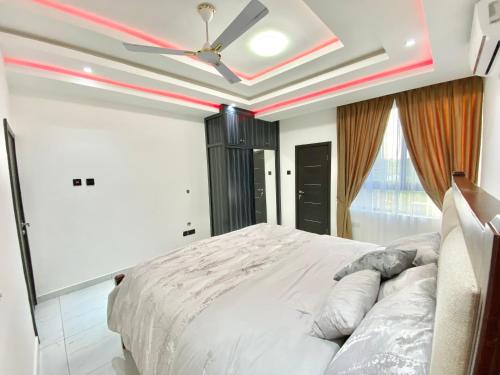 アクラにあるMankatiwa Court Apartmentsのベッドルーム1室(ベッド1台、シーリングファン付)