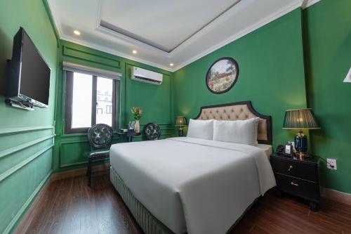 ein Schlafzimmer mit einem weißen Bett und grünen Wänden in der Unterkunft Madelise Adora Hotel & Travel in Hanoi