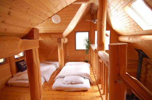 Cette chambre mansardée comprend 2 lits dans une cabane en rondins. dans l'établissement Shakunagedaira Rental Cottage - Vacation STAY 18468v, à Numajiri