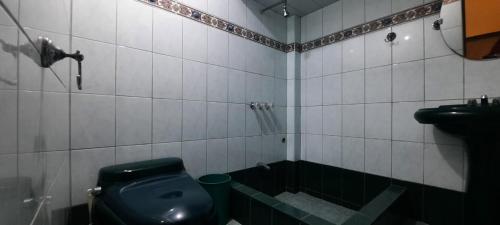 a bathroom with a black toilet and a sink at CASA TESORITOS in Urbanizacion Buenos Aires