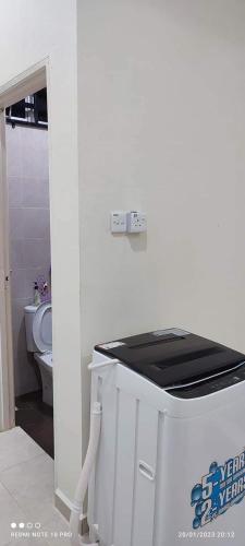 a white bathroom with a toilet and a sink at Homestay Haura Bella in Kampong Morak