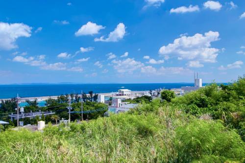 a view of a city with the ocean in the background at Takashi House in Nanjo