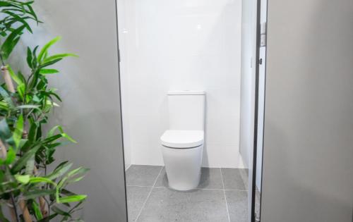 a bathroom with a white toilet in a stall at Mad Monkey East Side in Sydney