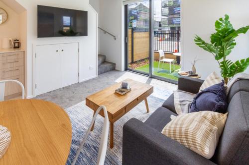 een woonkamer met een bank en een tafel bij Modern, Convenient, Central: 1 bedroom loft in Christchurch