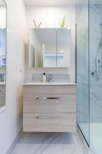 a bathroom with a sink and a mirror at Modern, Convenient, Central: 1 bedroom loft in Christchurch